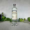 Bottle of St. George Spirits California Citrus gin on a neutral background with greenery.