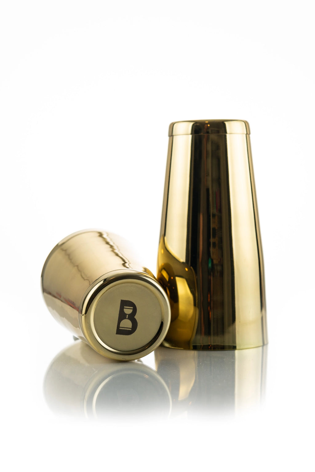 A gold-colored, weighted cocktail shaker with the letter 'B' engraved on the top.